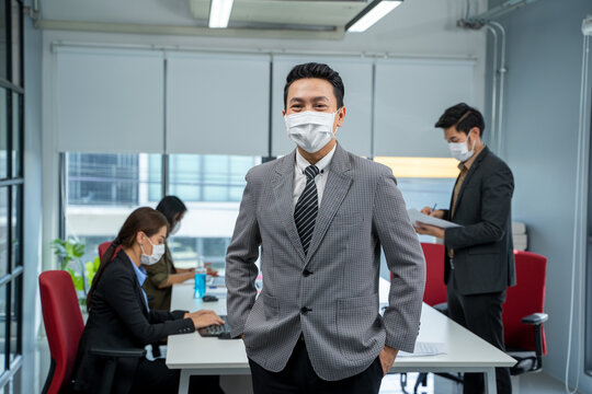 Businessman working and wear mask for protect Covid-19 or corona virus disease at model office,Healthcare concept.