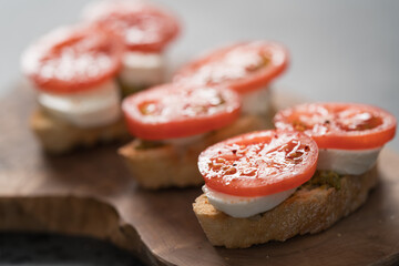 Italian ciabatta bread with mozzarella and tomatoes on olive board