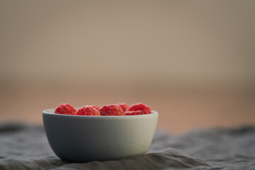 Yogurt with fresh raspberries in blue ceramic bowl on walnut table with copy space