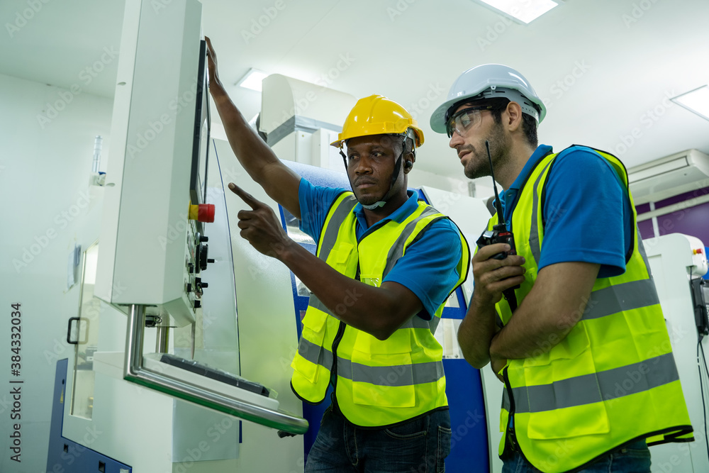 Poster engineer mechanic working and checking machine in a large industrial factory.