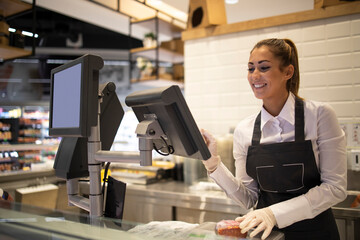 Supermarket worker measuring and selling meat to the customer. Working in grocery store.