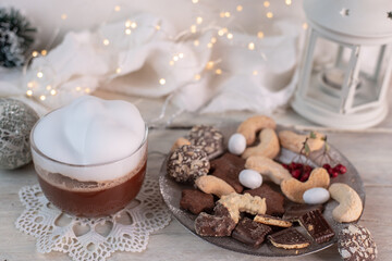 Fototapeta na wymiar Christmas cookies and sweets and hot chocolate with whipped cream on a very bright Christmas background