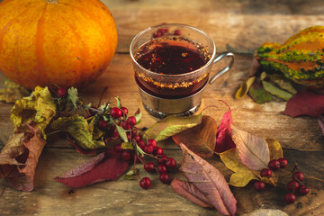 a glass of hot, aromatic tea on an autumn, warm background
