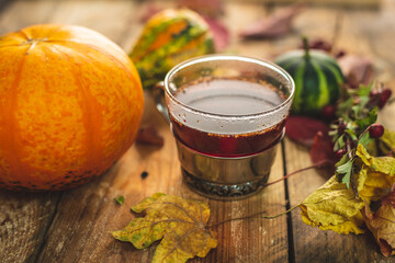 a glass of hot, aromatic tea on an autumn, warm background