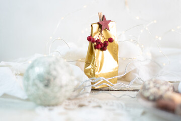 defocused white Christmas background with a golden gift