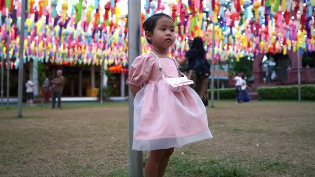Little girl stanting at Lantern Festival in Lamphun province Thailand.