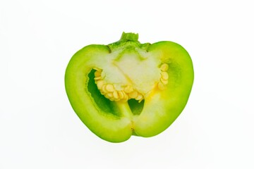 Green bell pepper in a cut with seeds on a white background.