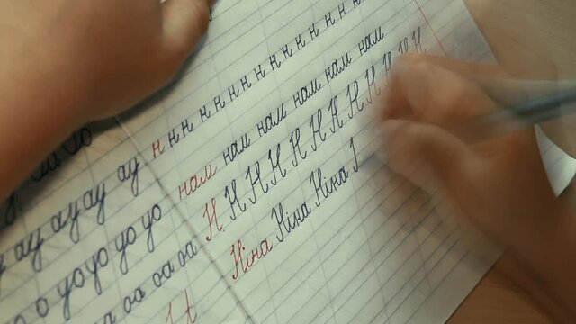 Accelerated footage of young boy learning how to write doing his exercises writing "Ніна" (Ukrainian for "Nina" - female name). Education concept.