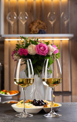 Two glasses of white wine are on the table.