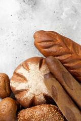 Rye bread. Rye bread of different shapes on a light gray table. Baguettes, loaves, round bread and rolls on the table. The view from the top. Copyspace. Banner