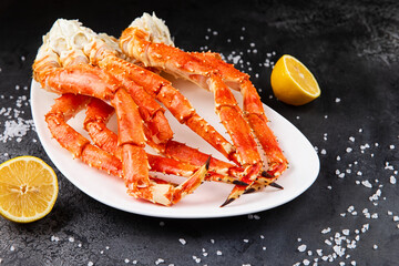 Crab legs in a plate on a dark background. Ready to eat.