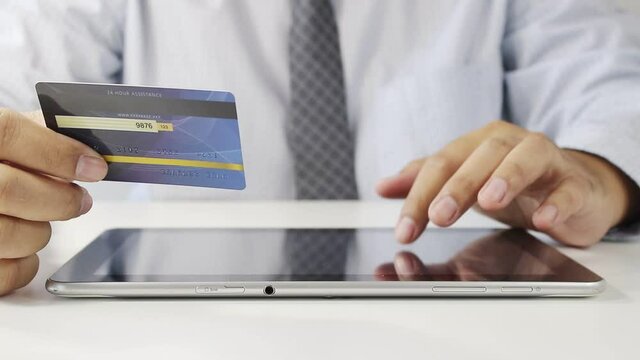 A man sat typing the credit card information on the notebook To apply for the service or perform financial transactions online. Modern business concepts