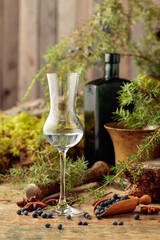 Gin, anise, and juniper berries on a wooden table.