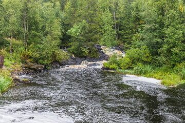 Park with the cascades of Akparhvenkoski waterfalls on the Tokhmayoki River, a popular tourist attraction situated near the settlement Ruskeala in Karelia, Russia