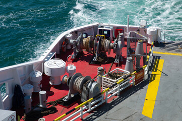 Large pulleys with steel cables on the aft deck of a ferry boat