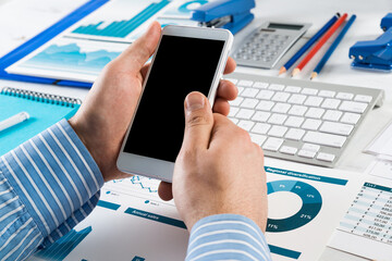 businessman with a smartphone, works in the office