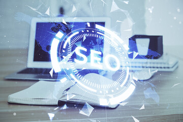 Multi exposure of table with computer and seo drawing hologram. Search optimization concept.