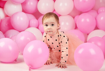 Fototapeta na wymiar Baby girl celebrate her first birthday. Girl on background of pink balloons