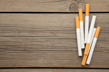 Cigarettes on grey wooden background. Top view.