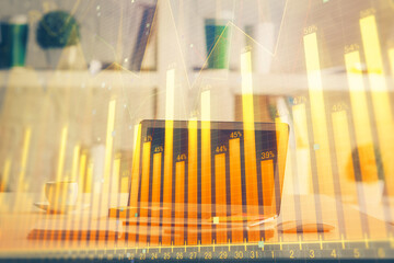 Stock market graph and table with computer background. Double exposure. Concept of financial analysis.