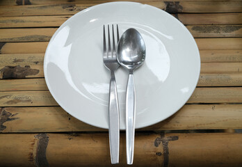 Focus on set of spoon and fork on white plate