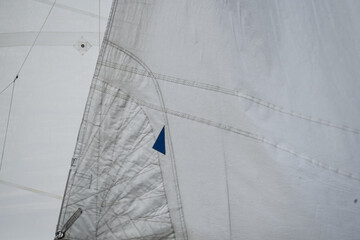 Close up of the stitches of a main sail and a jib