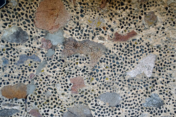 The wall of the building is made of chipped stone on a mortar. Beautiful texture