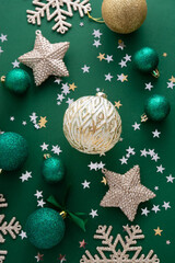 Christmas background with winter decorations, stars, baubles over green background.