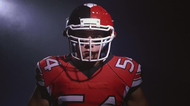 Portrait of determined professional American football player in helmet looking straight to camera ready for game. Confident man in uniform. Usa team game and extreme sport spirit concept.