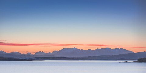 Isle of Skye landscape - orange and blue sky over mountains at sunrise