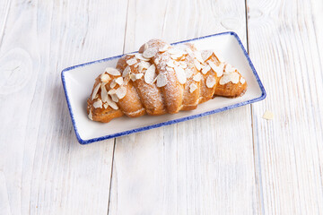croissant in a plate on a light board.