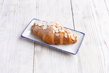 croissant in a plate on a light board.