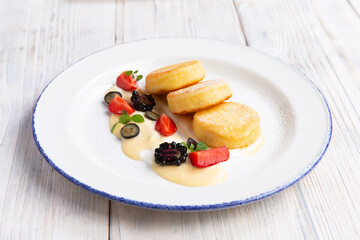 Cheesecakes traditional Russian food served with fresh berries