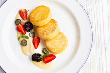 Cheesecakes traditional Russian food served with fresh berries