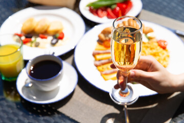 Breakfast outside. Fried eggs, coffee, croissants. Hands in the frame.