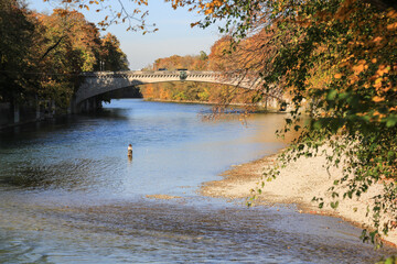 Eine Anglerin an der Isar in München im Herbst