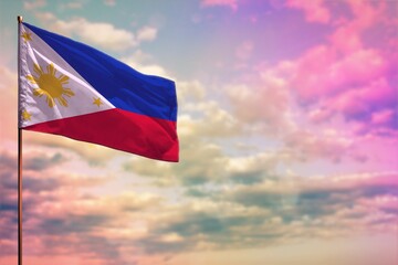 Fluttering Philippines flag mockup with the space for your content on colorful cloudy sky background.