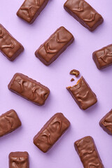 Chocolate bars pattern on a purple background viewed from above. Top view. Sweet checolate desserts