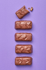 Chocolate bars on a purple background viewed from above. Top view. Sweet checolate desserts