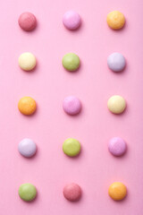 Colorful round candy sweets pattern on a pink background viewed from above. Top view