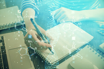 DNA theme hologram over woman's hands writing background. Concept of education. Double exposure © peshkova
