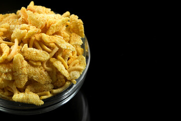 Indian snacks in bowl on dark background