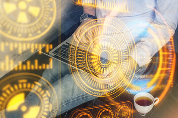 Technology theme hologram with man working on computer on background. High tech concept. Multi exposure.