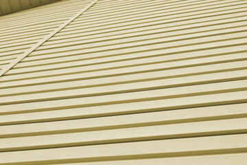 The striped surface of the plastic siding and piece of cornice. Construction and repair of buildings. Light olive background or wallpaper. Backdrop on the theme of building materials and technologies