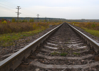 Fototapeta na wymiar railway tracks stretch into the distance in the autumn landscape