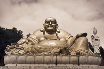Rich and fat Buddha sitting on stone, religion