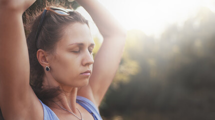 Meditating girl in beautiful style at sunset outdoors. Peaceful, quite and calm atmosphere.