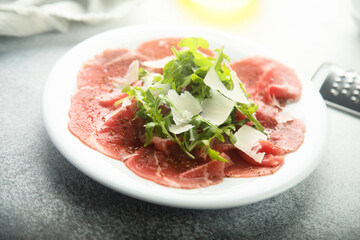 Traditional beef carpaccio with parmesan cheese and arugula