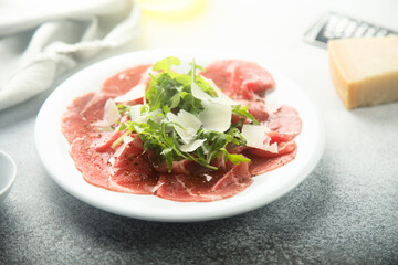 Traditional beef carpaccio with parmesan cheese and arugula