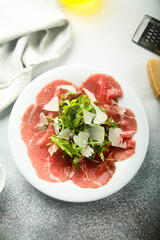 Traditional beef carpaccio with parmesan cheese and arugula